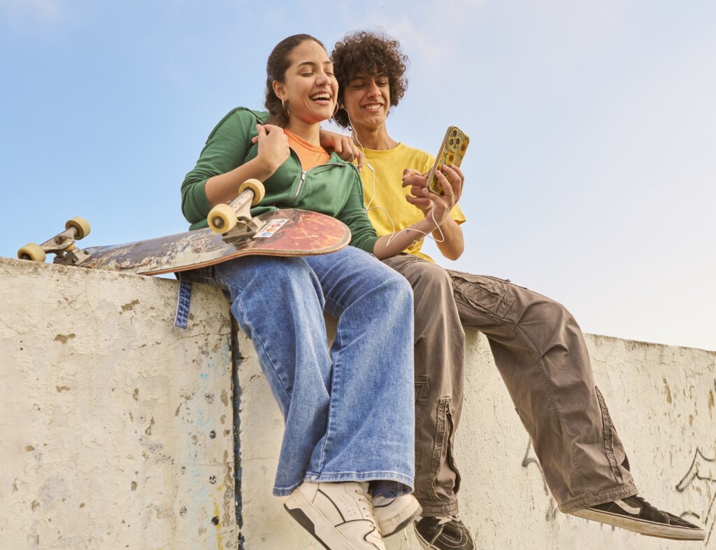 Age Verification decorative image, 2 young people watching their phone